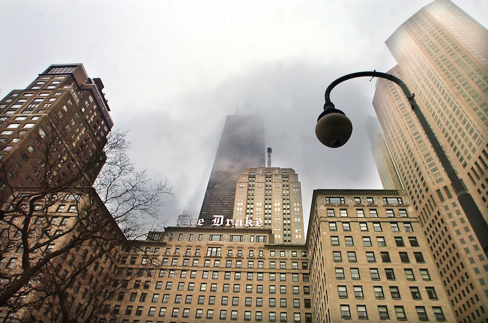 The iconic Drake Hotel, with the Hancock tower behind it shrouded in fog.