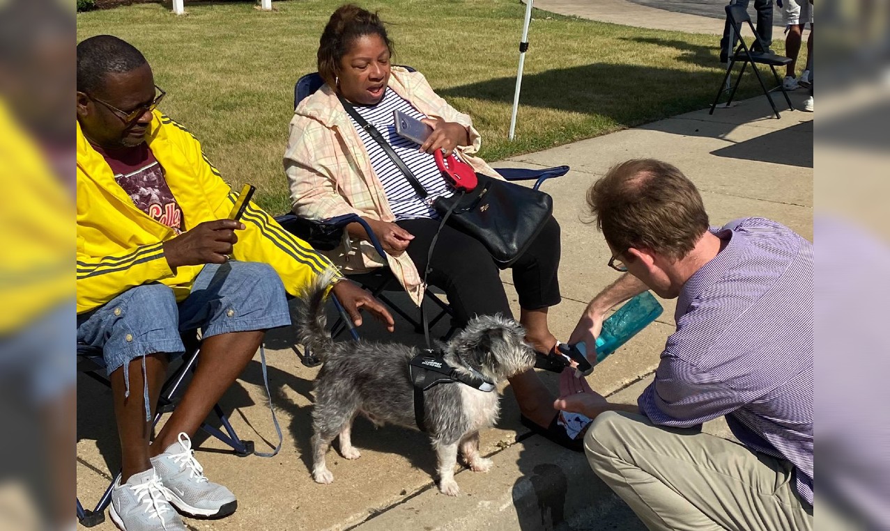 Senate Candidate Dem. Tom Nelson gives water to a thirsty pooch Saturday during the Juneteenth Day parade in Milwaukee.